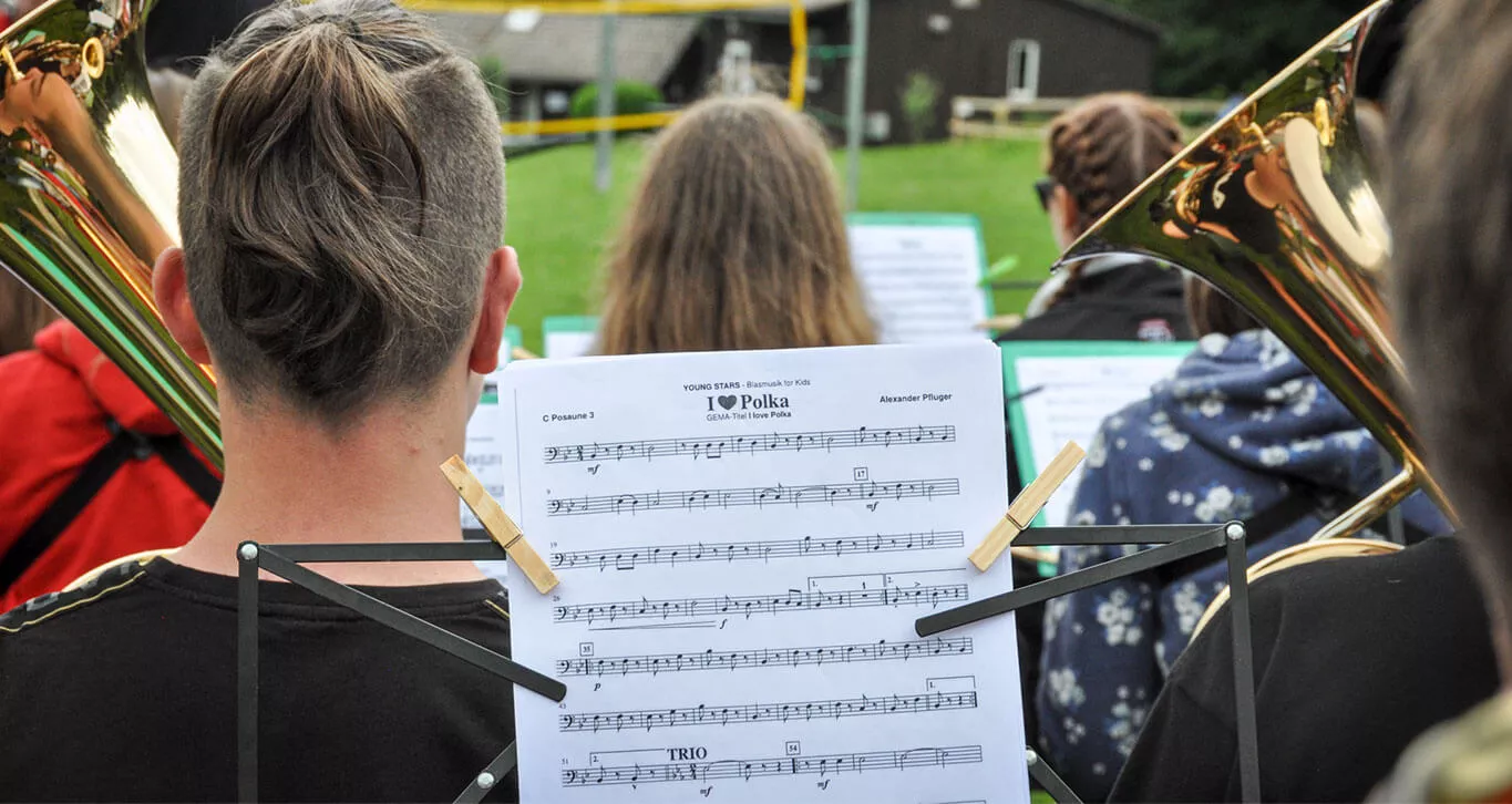 Mehrere Jugendliche sitzen in einem Orchester und spielen eine Polka.